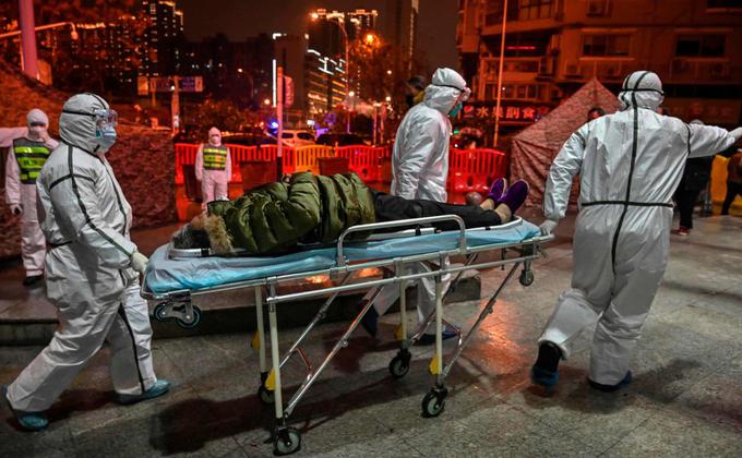 医务人员1月25日将疫情患者送入武汉市红十字会医院。(HECTOR RETAMAL/AFP via Getty Images)