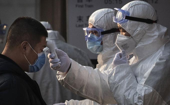 中国天津市武清区人民医院误诊一名武汉肺炎住院患者。图为中国卫生工作人员检查进入北京地铁站乘客的体温。(Kevin Frayer/Getty Images)